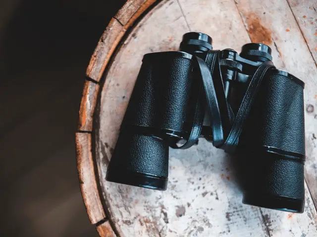 binoculars on a brown table