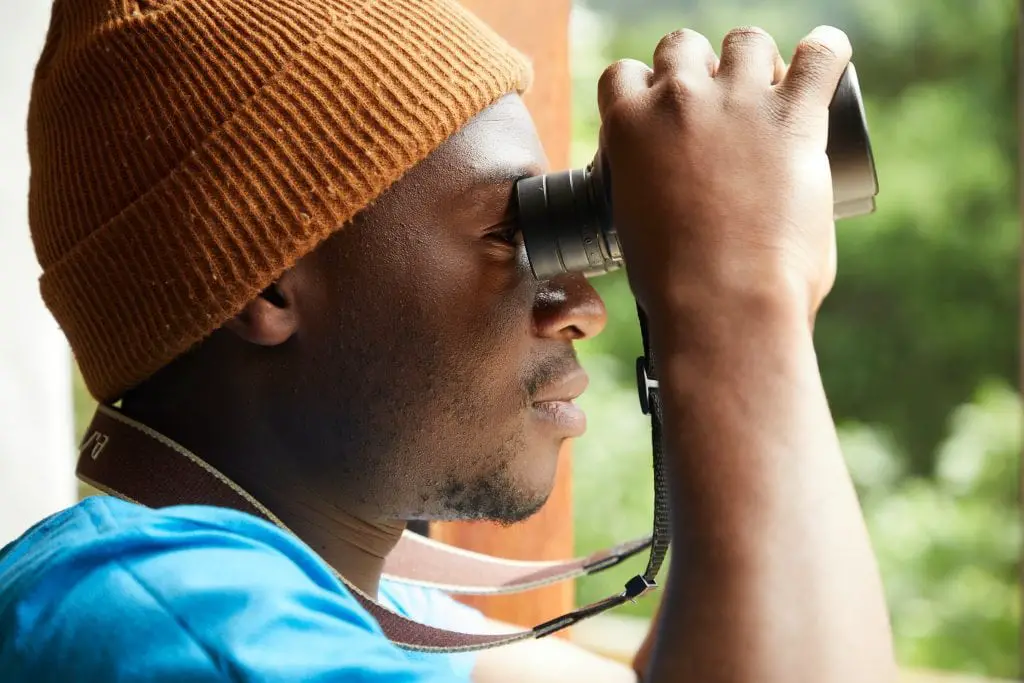 man looking through binoculars