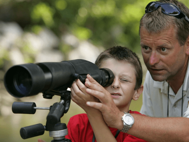 young and old man looking through a scope