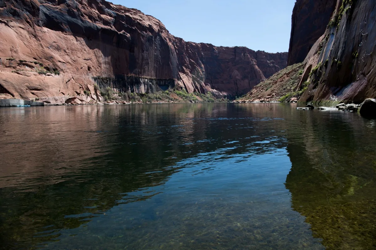 A river flows through red cliffs.