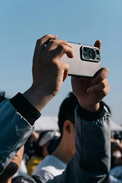 A person holding up a phone taking a photograph.